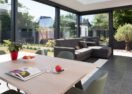 Moderne zwarte veranda in Maldegem met living en eetplaats - Van Der Bauwhede