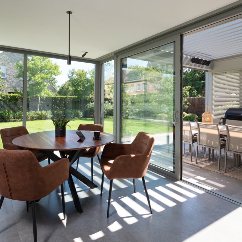 Moderne veranda met overkapping met lamellendak en lamellen schuifwand binnen