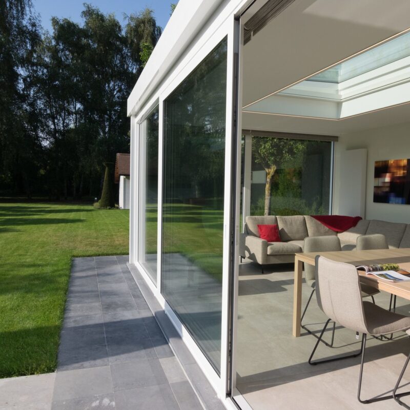 Moderne witte veranda met grote schuifdeuren in Sint-Amandsberg - Van Der Bauwhede