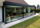 Moderne aanbouw veranda met grote glaspartijen in Blankenberge door Van Der Bauwhede