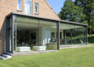 Grote moderne aanbouw veranda met plat dak en trapje in Grez Doiceau Graven Waals Brabant Van Der Bauwhede