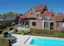 Moderne aanbouw veranda in Ninove met zicht op de tuin en het buitenzwembad