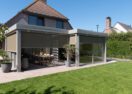 Moderne veranda met overkapping met klamellendak en lamellen schuifwand buiten