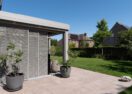 Moderne veranda met overkapping met lamellendak en lamellen schuifwand schuifwand open