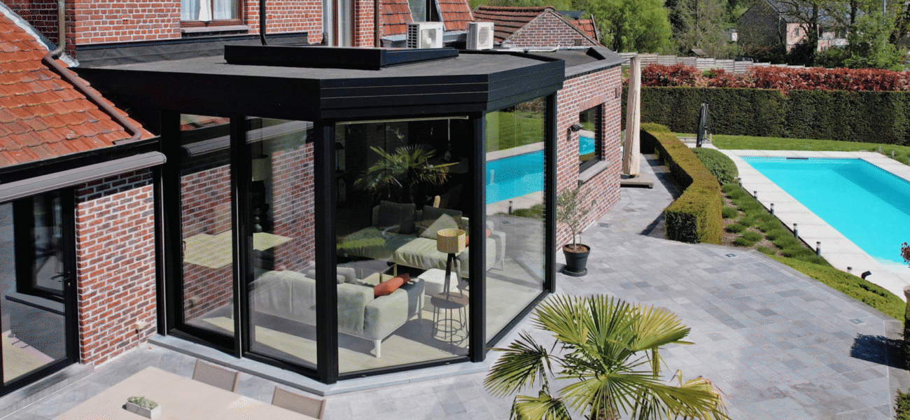 Moderne zwarte aanbouw veranda met zicht op het buitenzwembad in Ninove
