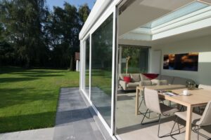 Moderne witte veranda met grote schuifdeuren in Sint-Amandsberg - Van Der Bauwhede